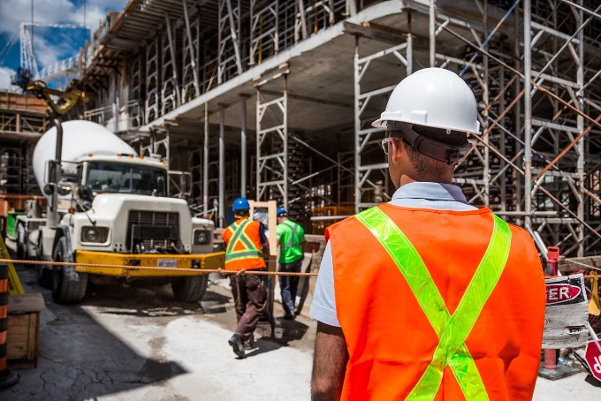 work site image with workers and trucks to introduce paragraph about construction